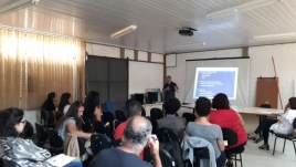 Sala com pessoas sentadas na capacitação.